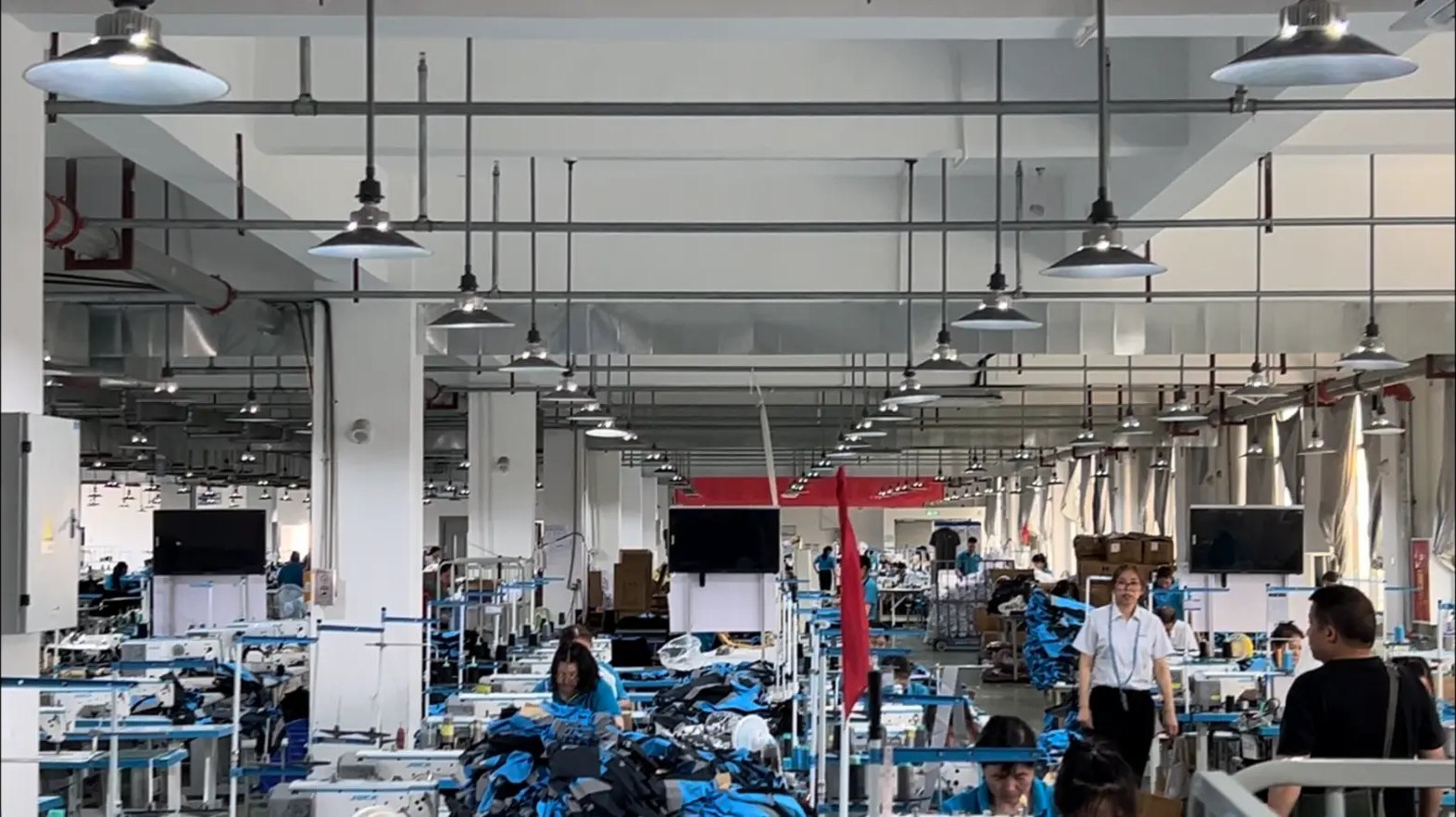 Large sewing floor with rows of workstations and workers