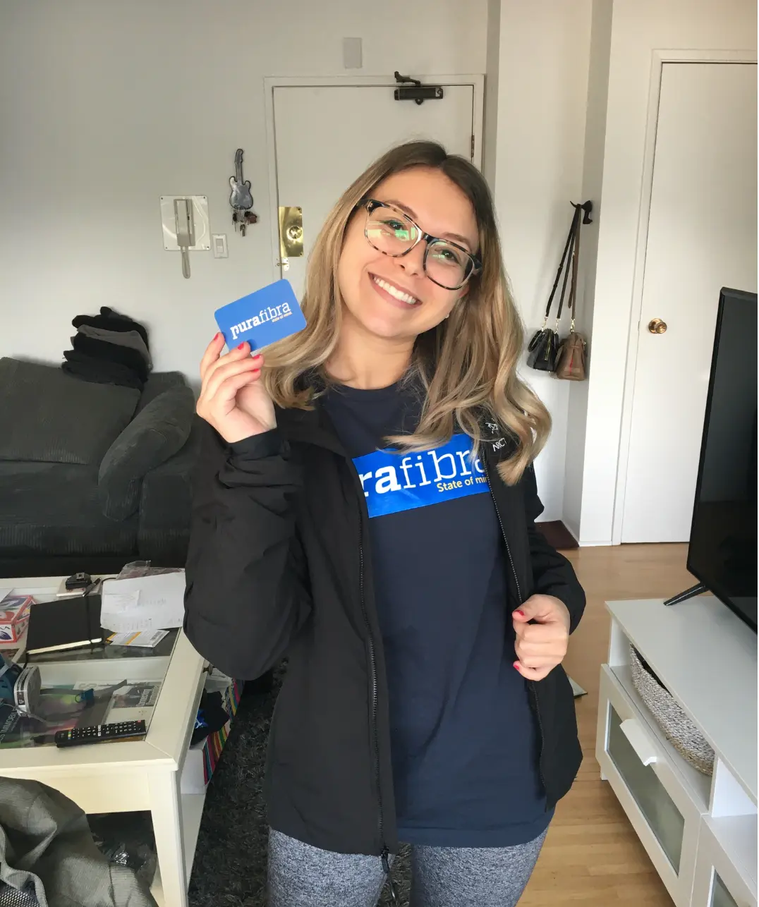 Sophia segurando um cartão da Pura Fibra
