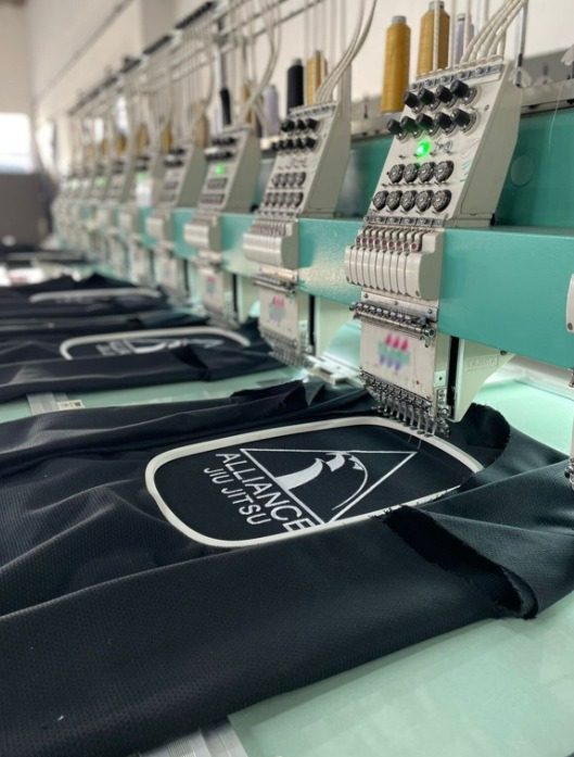 Tajima multi-head embroidery department with organized garments