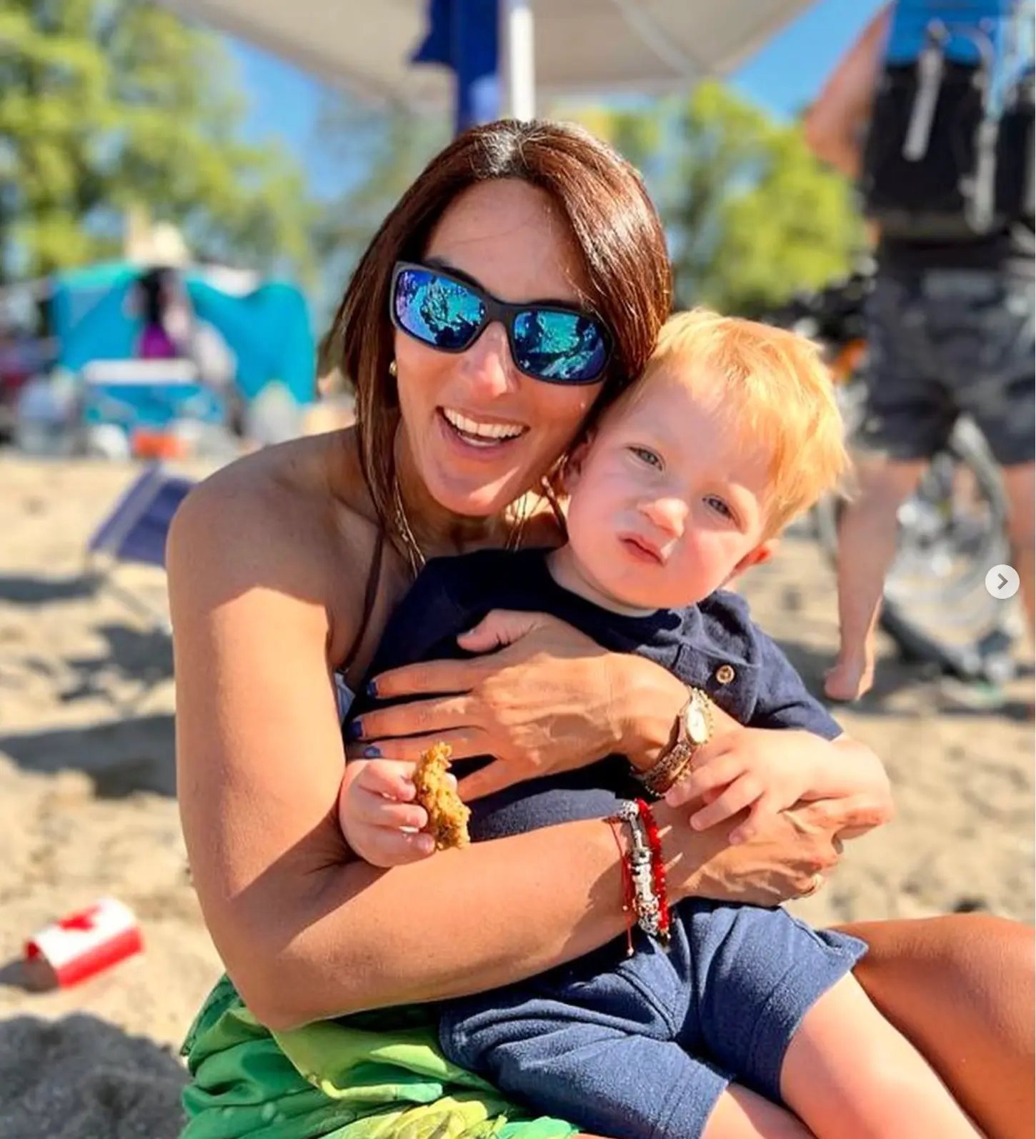 Chanti segurando uma criança na praia