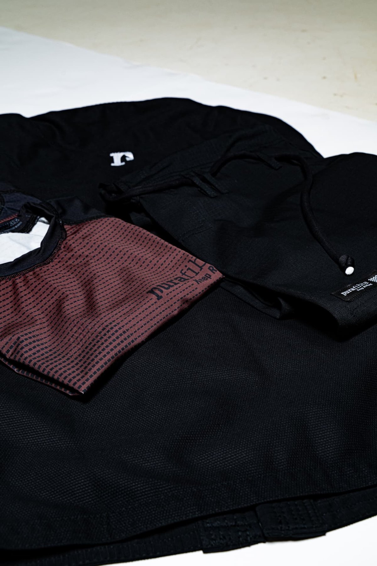 Burgundy Pura Fibra rashguard with black shorts and gi