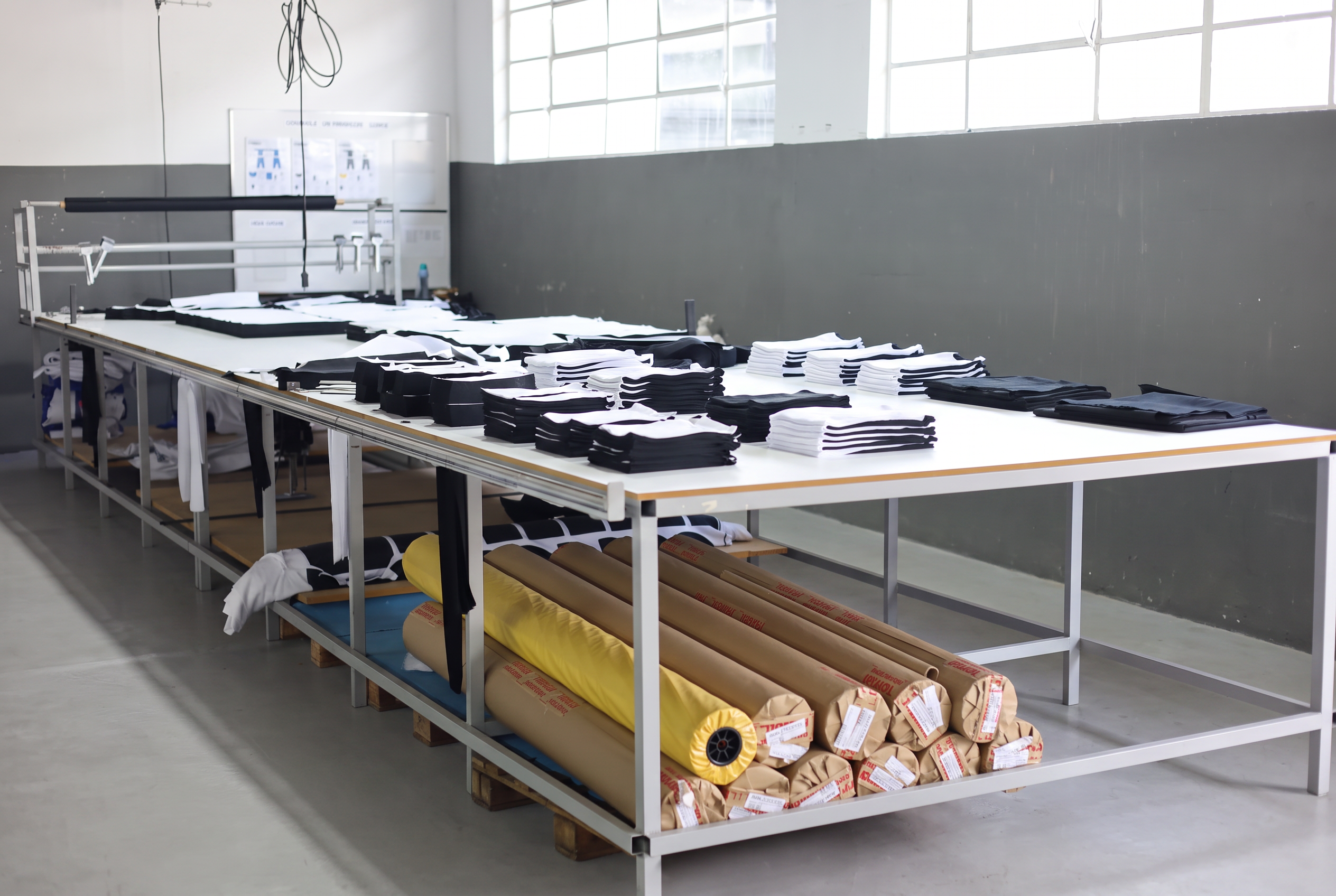 Cutting table with organized garment panels and rolls of fabric