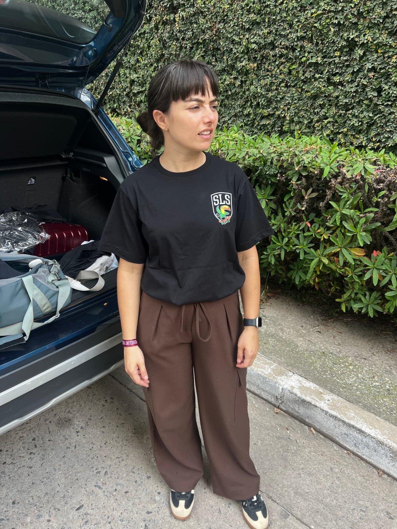 Camila Buse standing beside an open car trunk